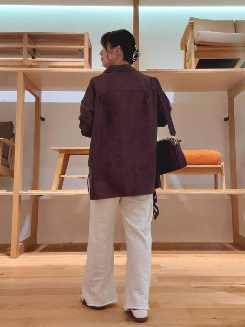 レッド系のショルダーバッグ、ブラウン系のシャツ/ブラウス、ブラック系のバンダナ/スカーフを着用したレディースの秋コーディネートの3枚目の写真