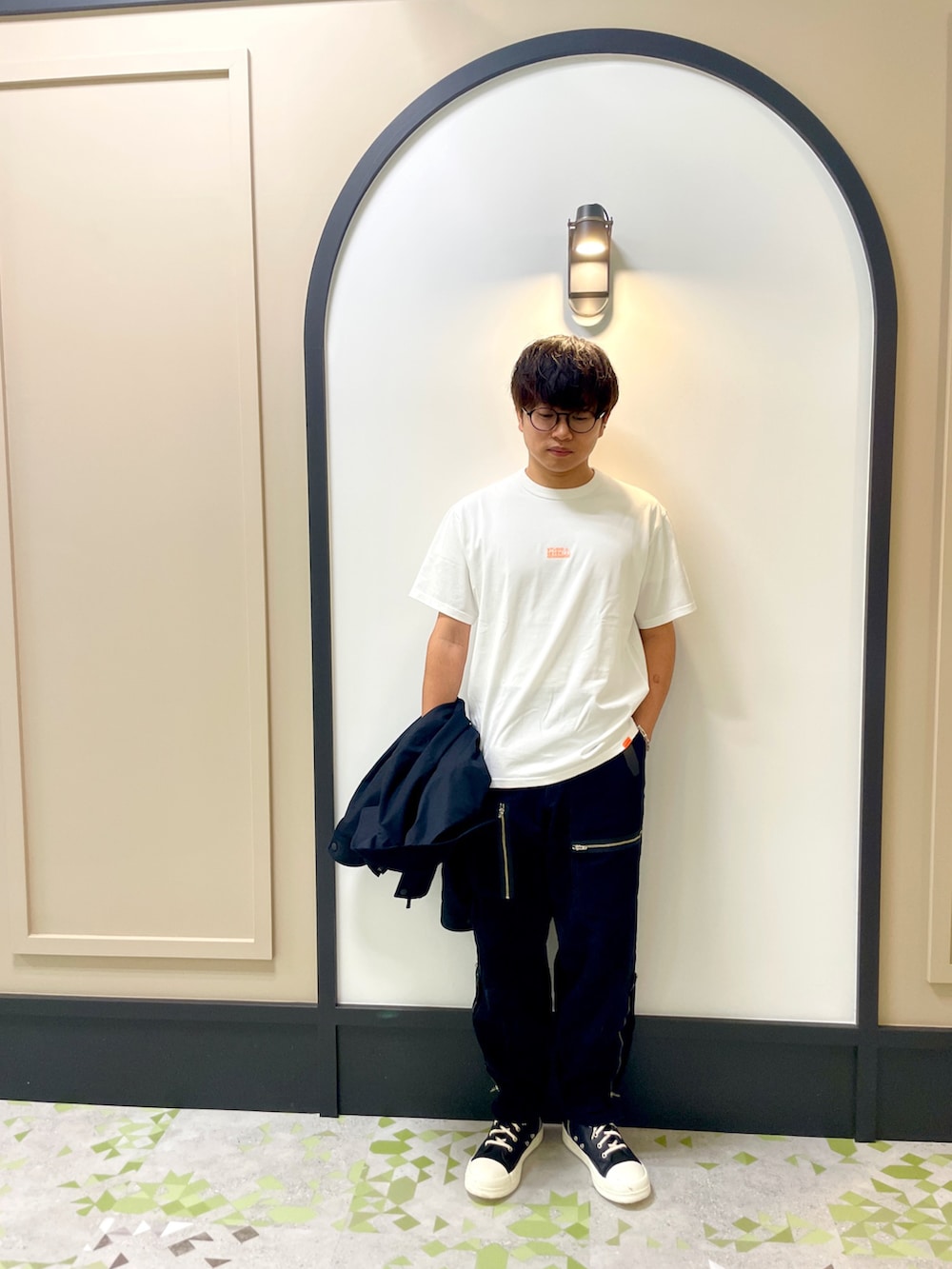 ホワイト系のTシャツ/カットソー、ブラック系のミリタリージャケット、ブラック系のカーゴパンツを着用したメンズの秋コーディネートの2枚目の写真
