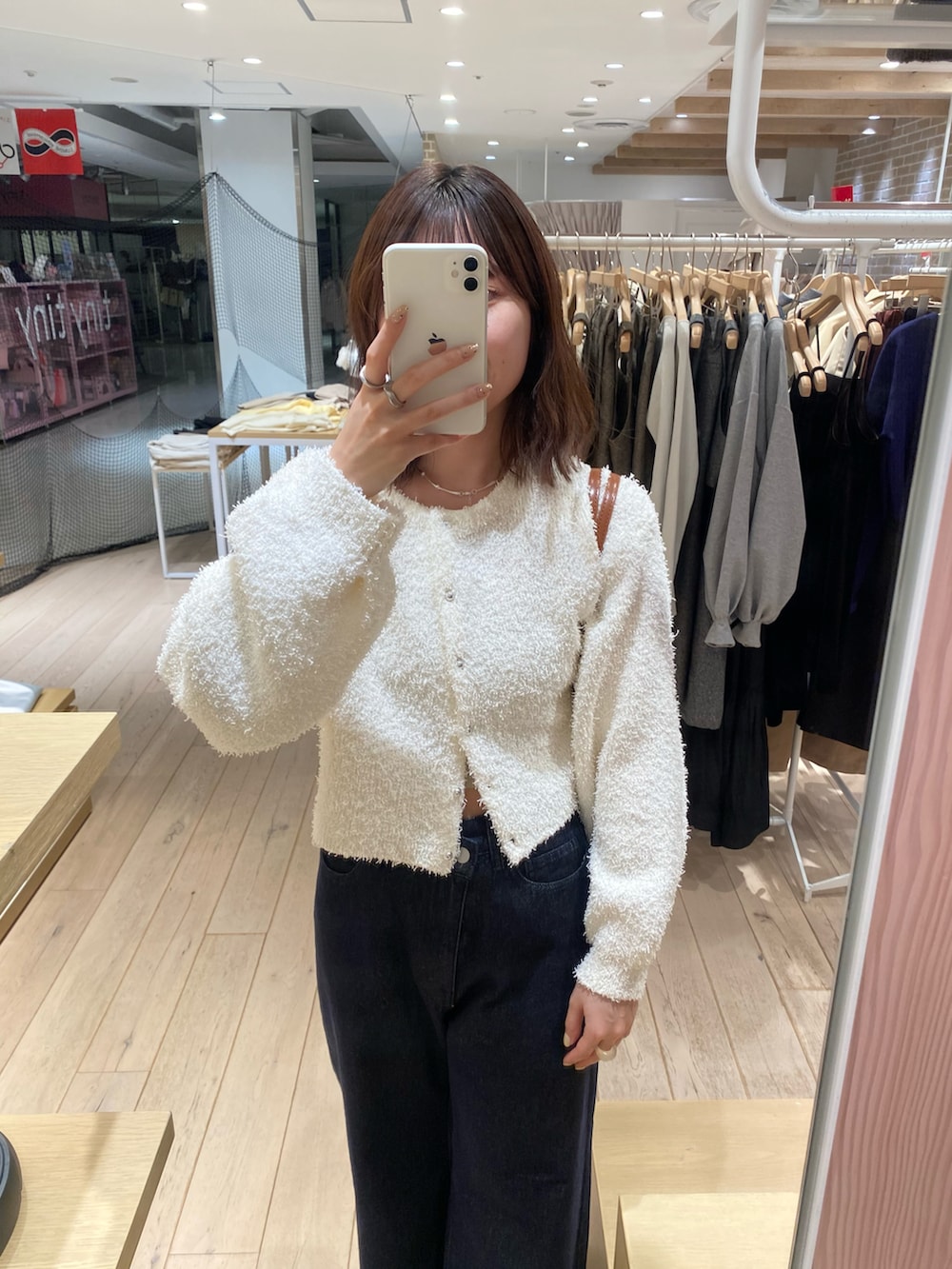 ホワイト系のカーディガン/ボレロ、ブルー系のデニムパンツを着用したレディースの冬コーディネートの2枚目の写真