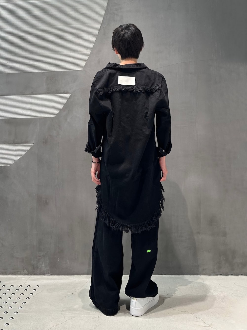 ブラック系のシャツワンピース、ブラック系のデニムパンツ、ホワイト系のスニーカーを着用したメンズの夏コーディネートの3枚目の写真