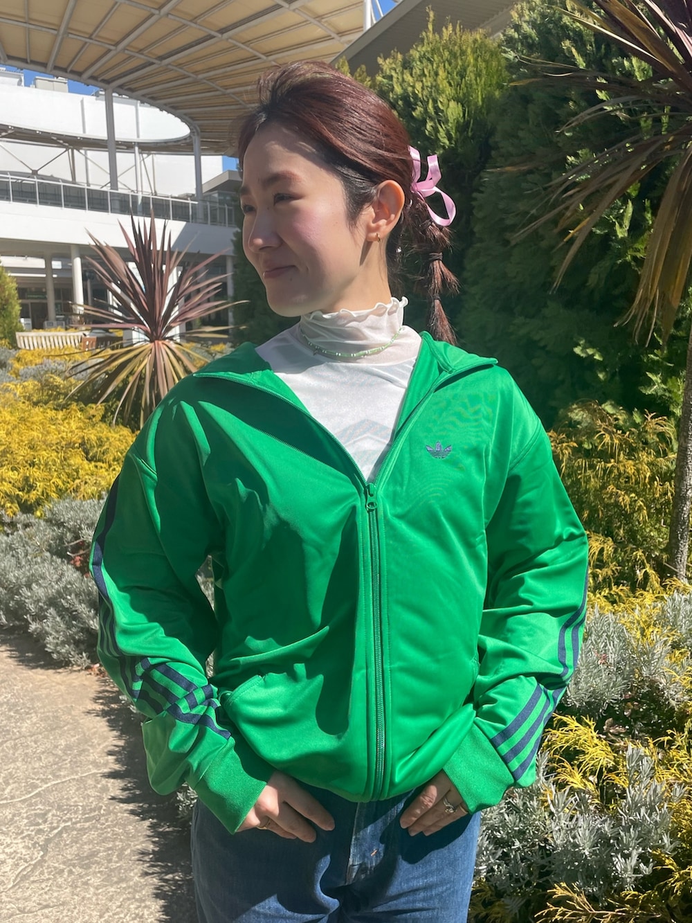 グリーン系のジャージ、レッド系のスニーカーを着用したレディースの春コーディネートの3枚目の写真