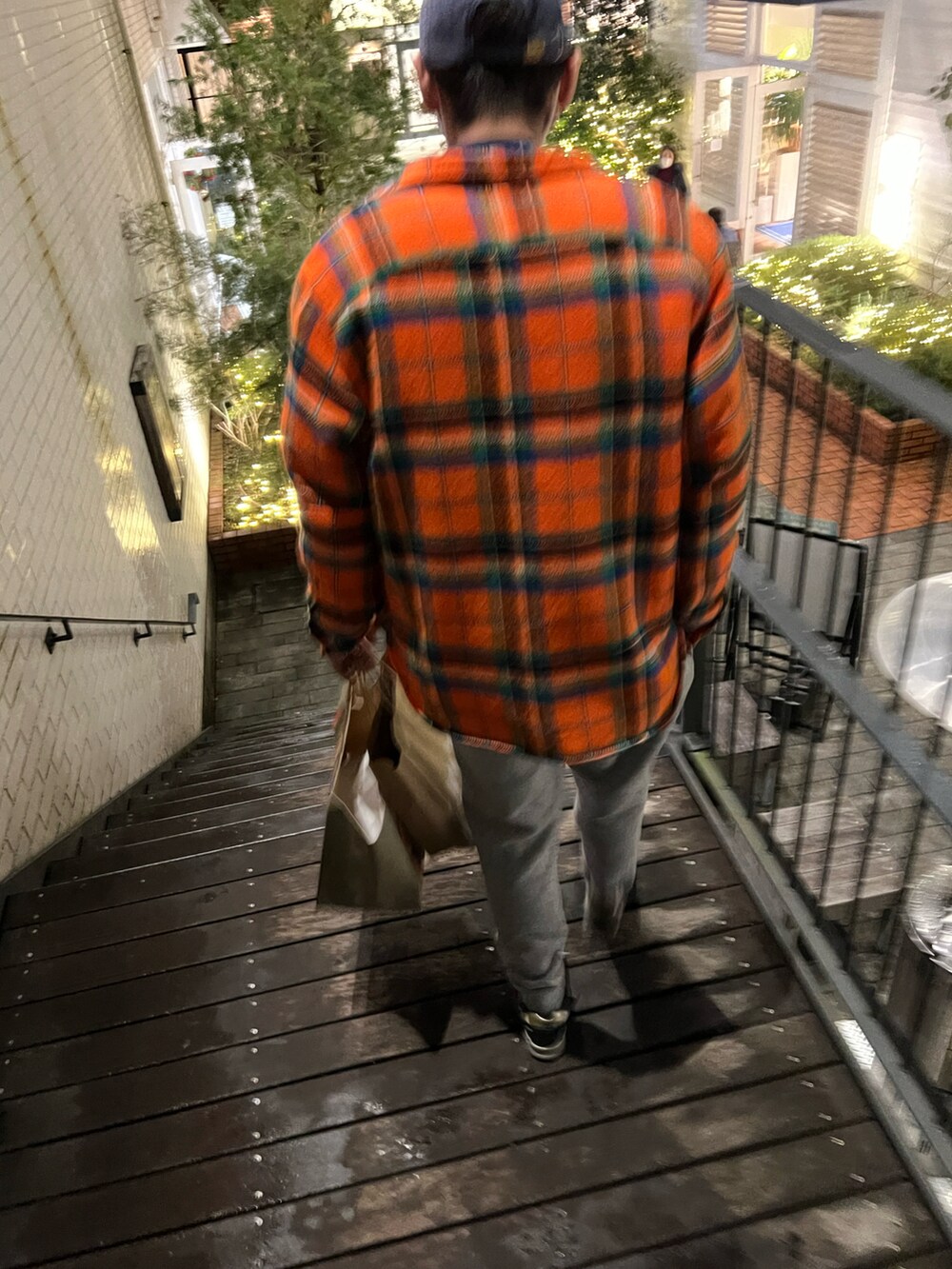 グレー系のスウェットパンツ、オレンジ系のジャケット/アウター、ブラック系のスニーカーを着用したメンズの冬コーディネートの2枚目の写真