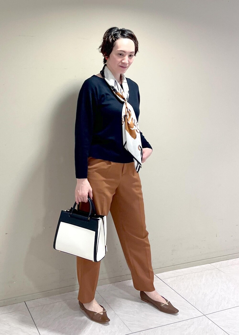 ブルー系のニット/セーター、ブラウン系のパンプス、ブラウン系のその他パンツを着用したレディースの秋コーディネートの4枚目の写真