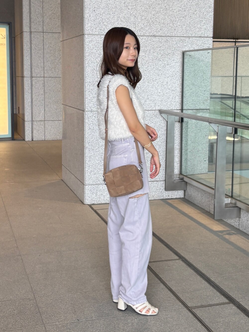 ベージュ系のショルダーバッグを着用したレディースの夏コーディネートの2枚目の写真