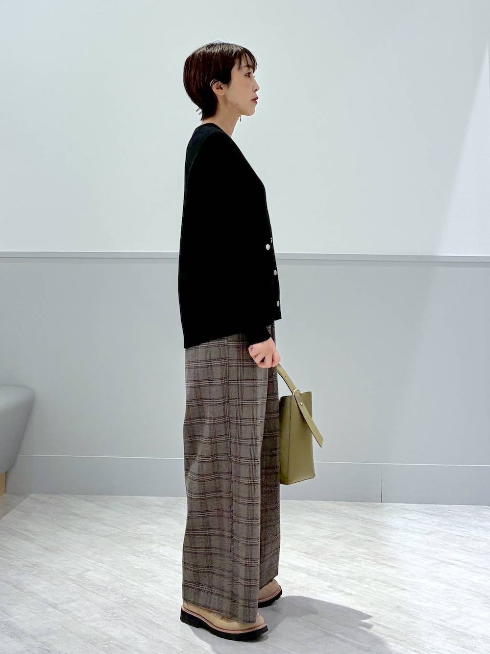 グリーン系のショルダーバッグ、ブラック系のカーディガン/ボレロ、ブラウン系のその他パンツを着用したレディースの秋コーディネートの5枚目の写真