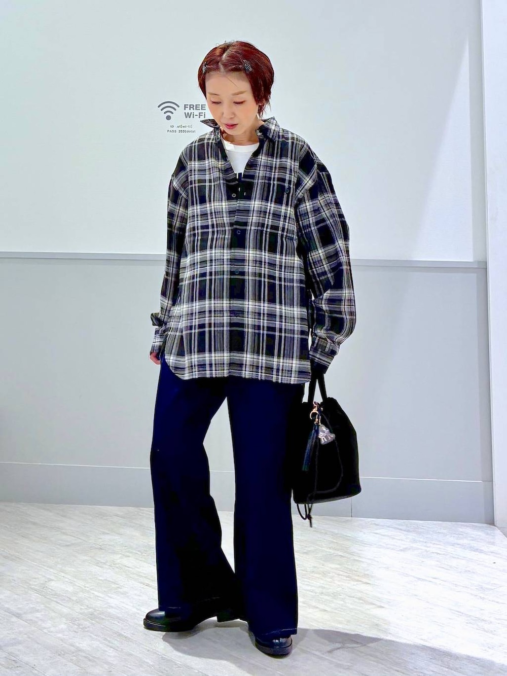 ブラック系のハンドバッグ、ブラック系のその他シューズ、ホワイト系のTシャツ/カットソーを着用したレディースの夏コーディネートの2枚目の写真