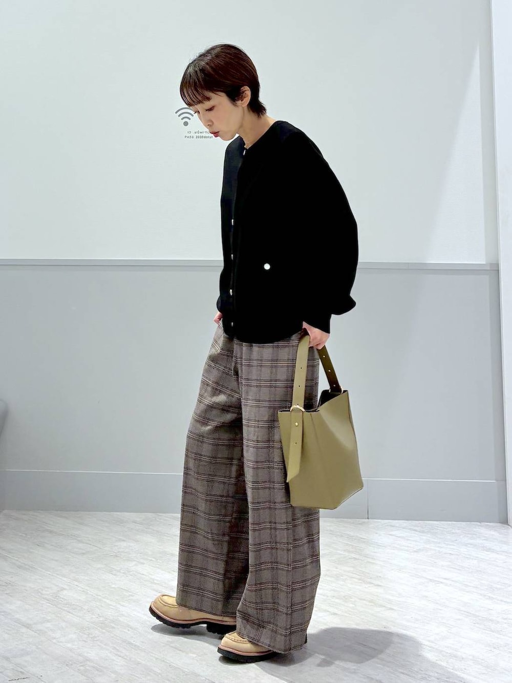 グリーン系のショルダーバッグ、ブラック系のカーディガン/ボレロ、ブラウン系のその他パンツを着用したレディースの秋コーディネートの2枚目の写真