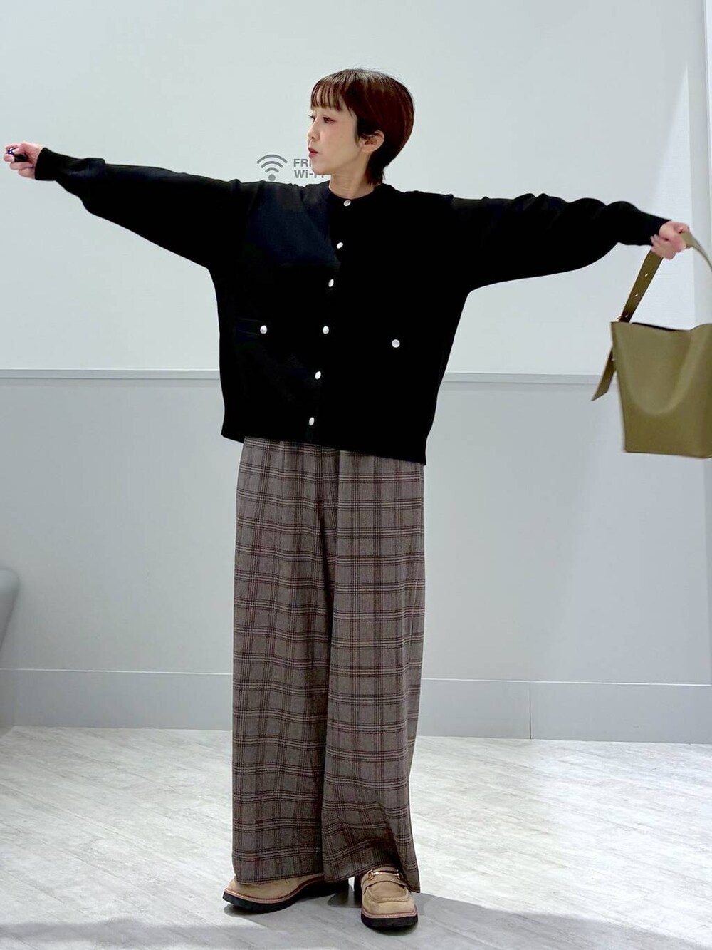 グリーン系のショルダーバッグ、ブラック系のカーディガン/ボレロ、ブラウン系のその他パンツを着用したレディースの秋コーディネートの3枚目の写真