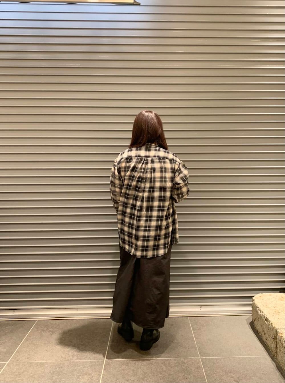 ブラック系のワンピース、ホワイト系のTシャツ/カットソー、ブラック系のブーツを着用したレディースの秋コーディネートの3枚目の写真