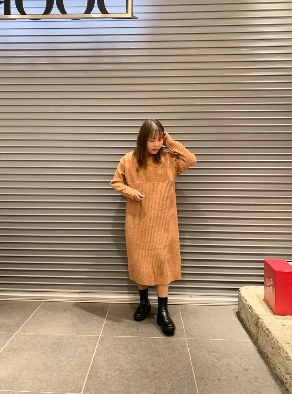 ホワイト系のダウンジャケット/コート、ブラック系のブーツ、オレンジ系のワンピースを着用したレディースの冬コーディネートの4枚目の写真