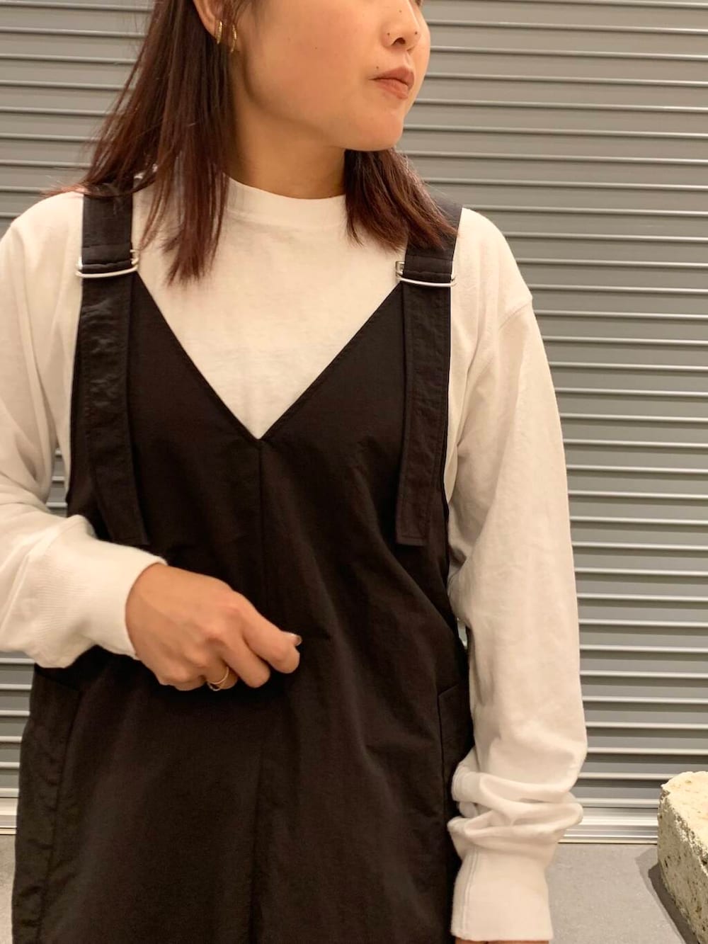 ブラック系のワンピース、ホワイト系のTシャツ/カットソー、ブラック系のブーツを着用したレディースの秋コーディネートの7枚目の写真