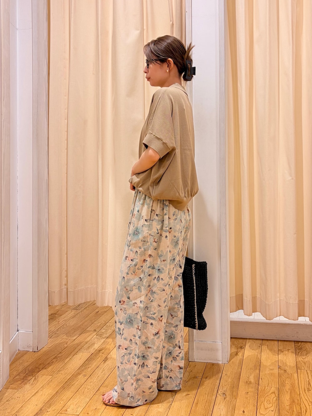 ベージュ系のニット/セーター、ブルー系のその他パンツ、ブラック系のトートバッグを着用したレディースの夏コーディネートの2枚目の写真