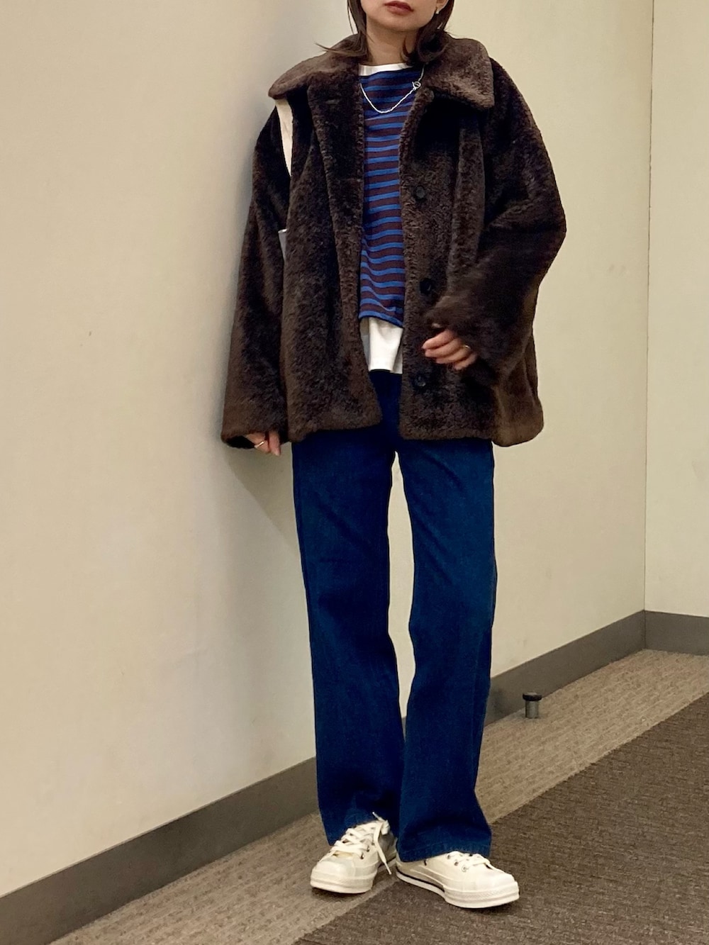 ブラウン系のTシャツ/カットソー、ブラウン系のその他アウター、ブルー系のデニムパンツを着用したレディースの秋コーディネートの4枚目の写真