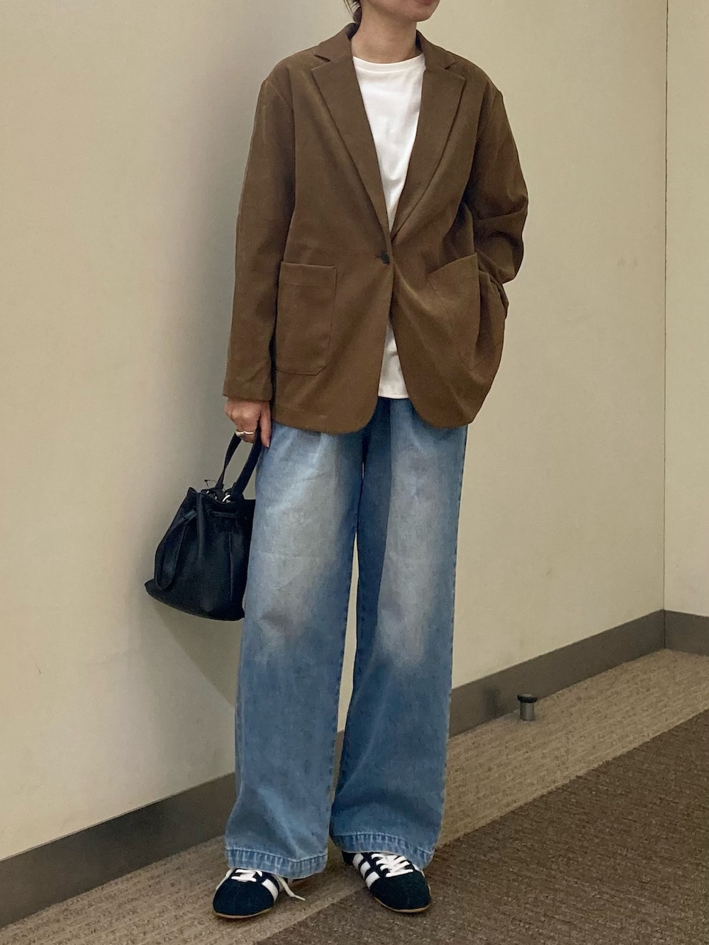 ホワイト系のTシャツ/カットソー、ベージュ系のその他アウター、ブルー系のデニムパンツを着用したレディースの秋コーディネートの5枚目の写真