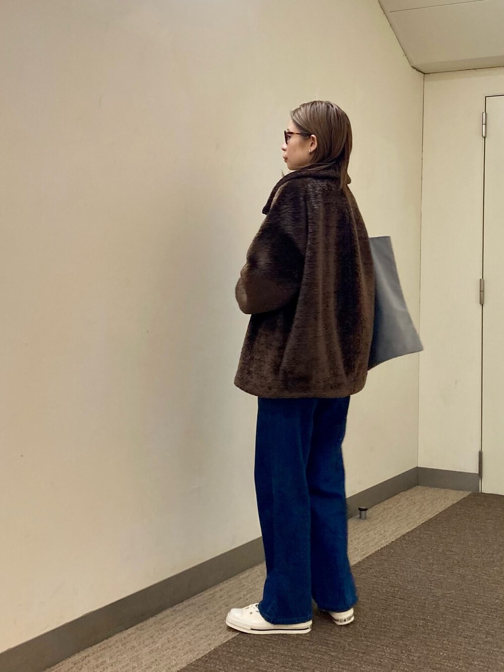 ブラウン系のTシャツ/カットソー、ブラウン系のその他アウター、ブルー系のデニムパンツを着用したレディースの秋コーディネートの2枚目の写真