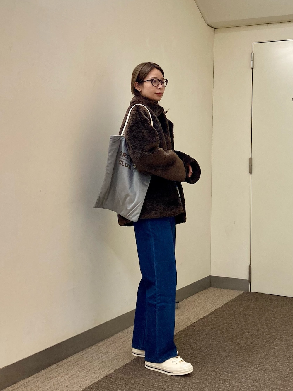 ブラウン系のTシャツ/カットソー、ブラウン系のその他アウター、ブルー系のデニムパンツを着用したレディースの秋コーディネートの5枚目の写真