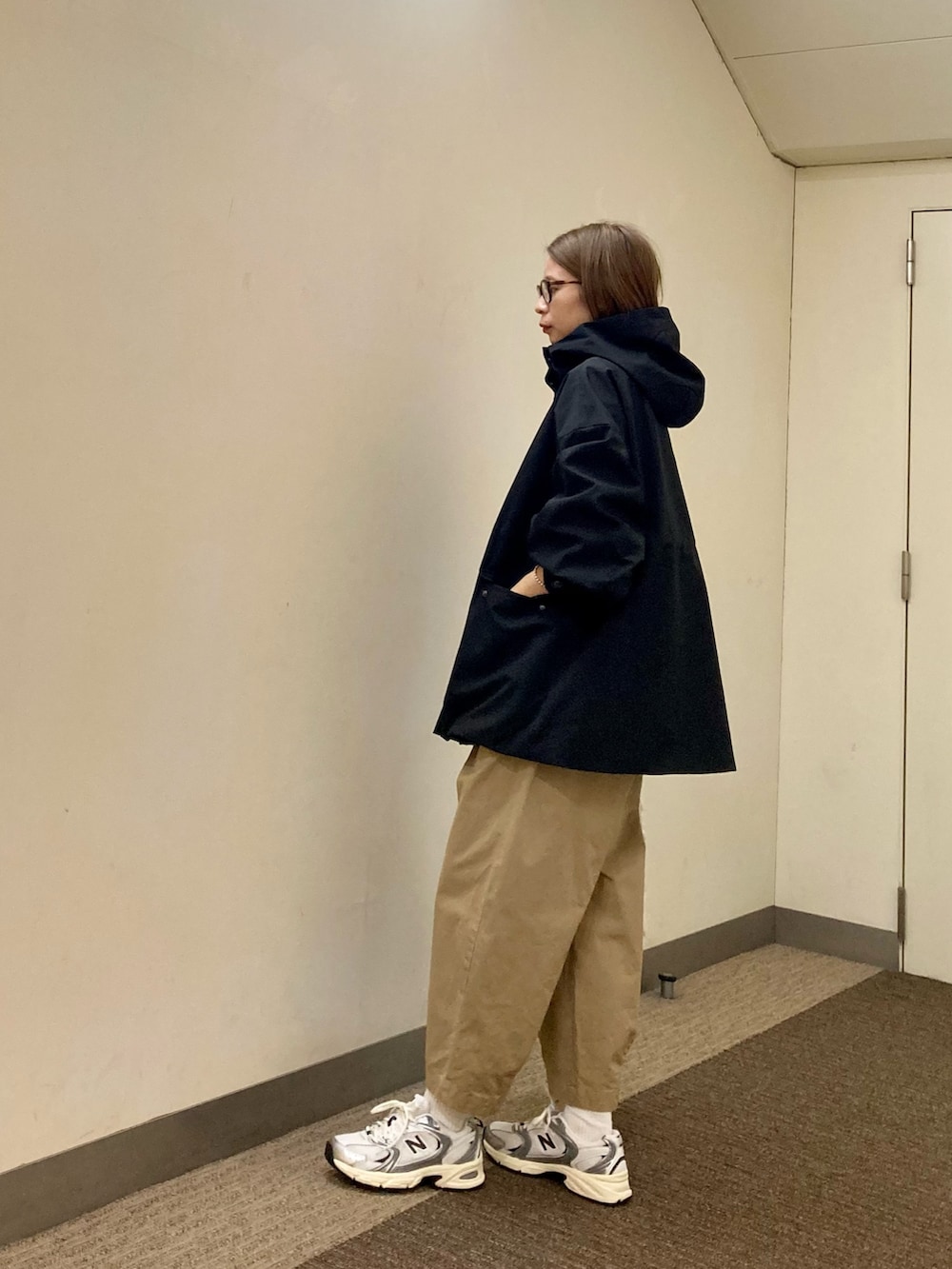 ブラック系のその他アウター、ベージュ系のその他パンツ、ベージュ系のショルダーバッグを着用したレディースの秋コーディネートの2枚目の写真