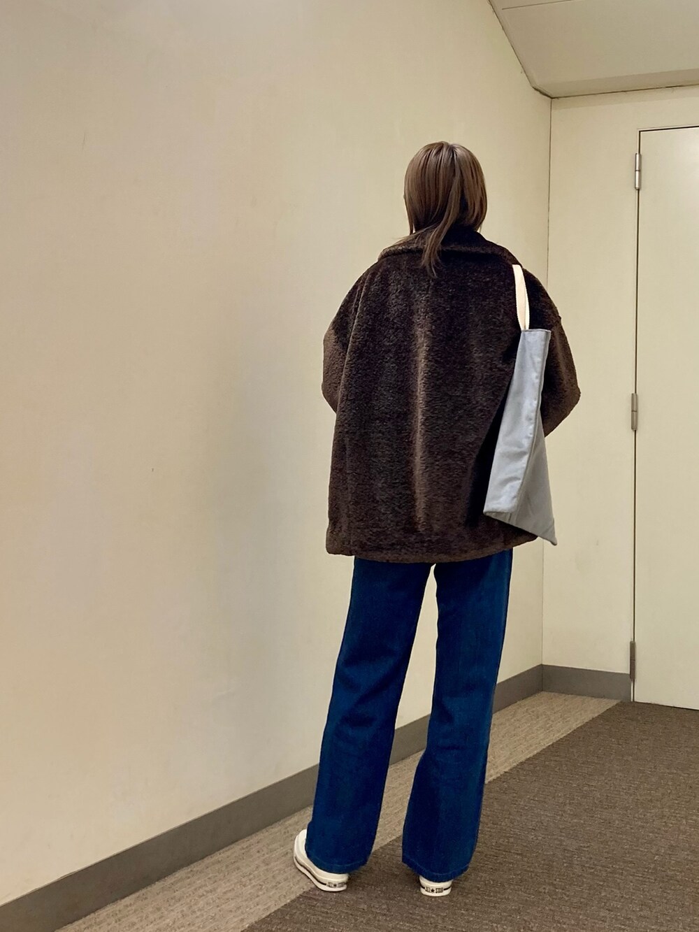 ブラウン系のTシャツ/カットソー、ブラウン系のその他アウター、ブルー系のデニムパンツを着用したレディースの秋コーディネートの3枚目の写真