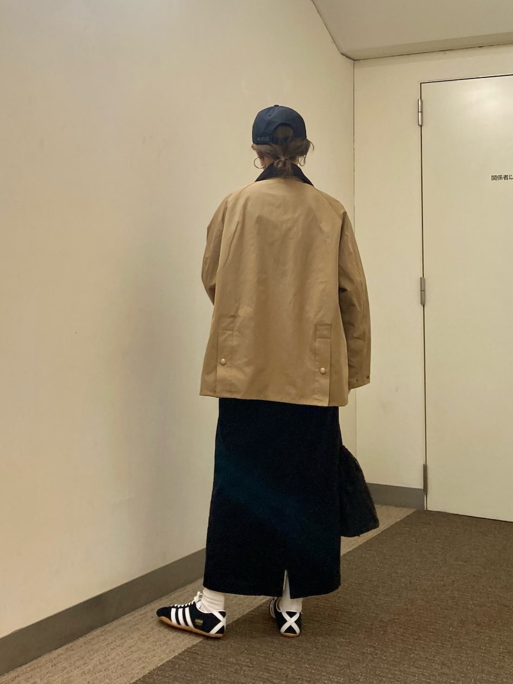 ベージュ系のその他アウター、ブラック系のスカート、ブラック系のショルダーバッグを着用したレディースの秋コーディネートの3枚目の写真