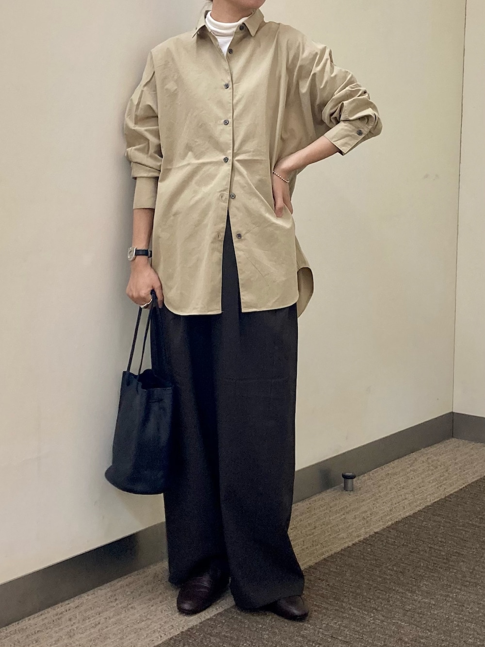 ブラウン系のパンプス、ブラック系のショルダーバッグ、ホワイト系のTシャツ/カットソーを着用したレディースの秋コーディネートの5枚目の写真