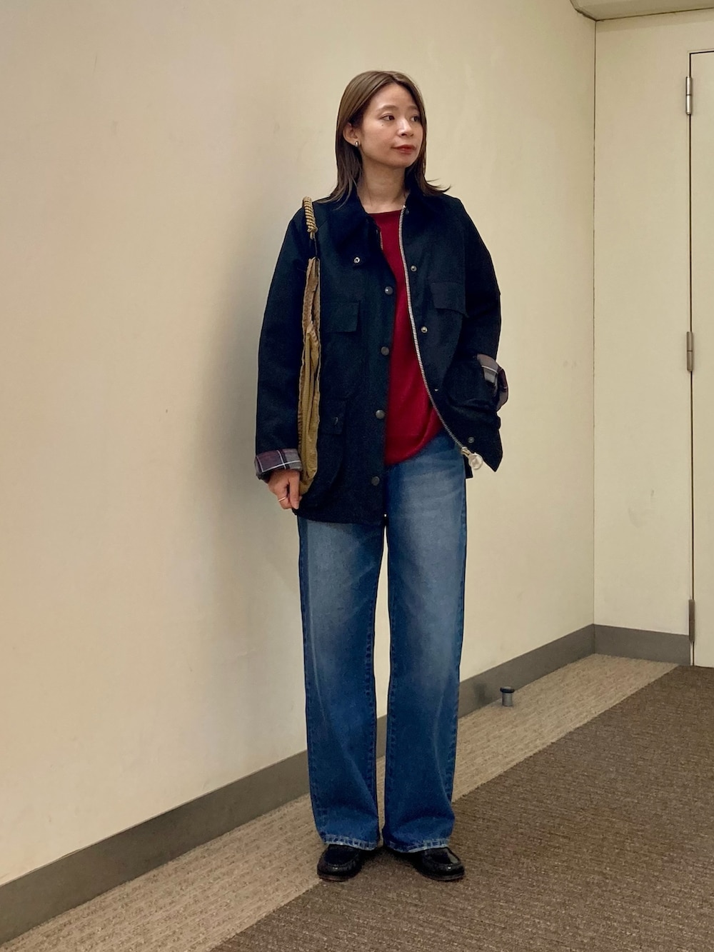 ブラック系のその他アウター、ブルー系のデニムパンツ、レッド系のニット/セーターを着用したレディースの秋コーディネートの6枚目の写真