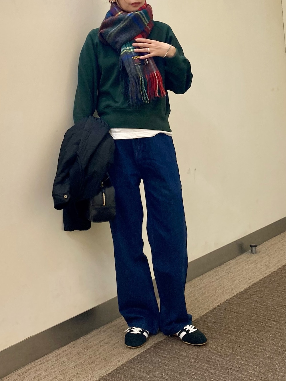 グリーン系のスウェット、ホワイト系のTシャツ/カットソー、ブルー系のデニムパンツを着用したレディースの秋コーディネートの4枚目の写真