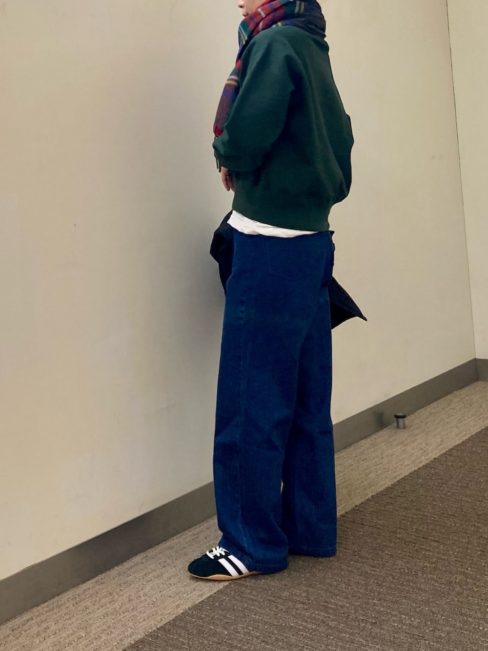 グリーン系のスウェット、ホワイト系のTシャツ/カットソー、ブルー系のデニムパンツを着用したレディースの秋コーディネートの2枚目の写真