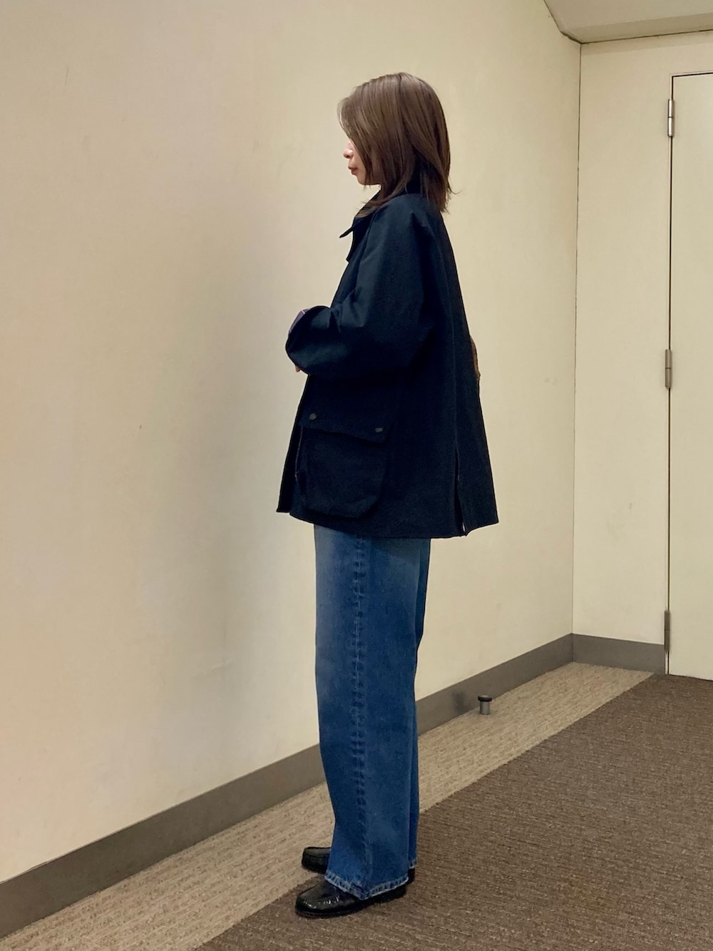 ブラック系のその他アウター、ブルー系のデニムパンツ、レッド系のニット/セーターを着用したレディースの秋コーディネートの3枚目の写真