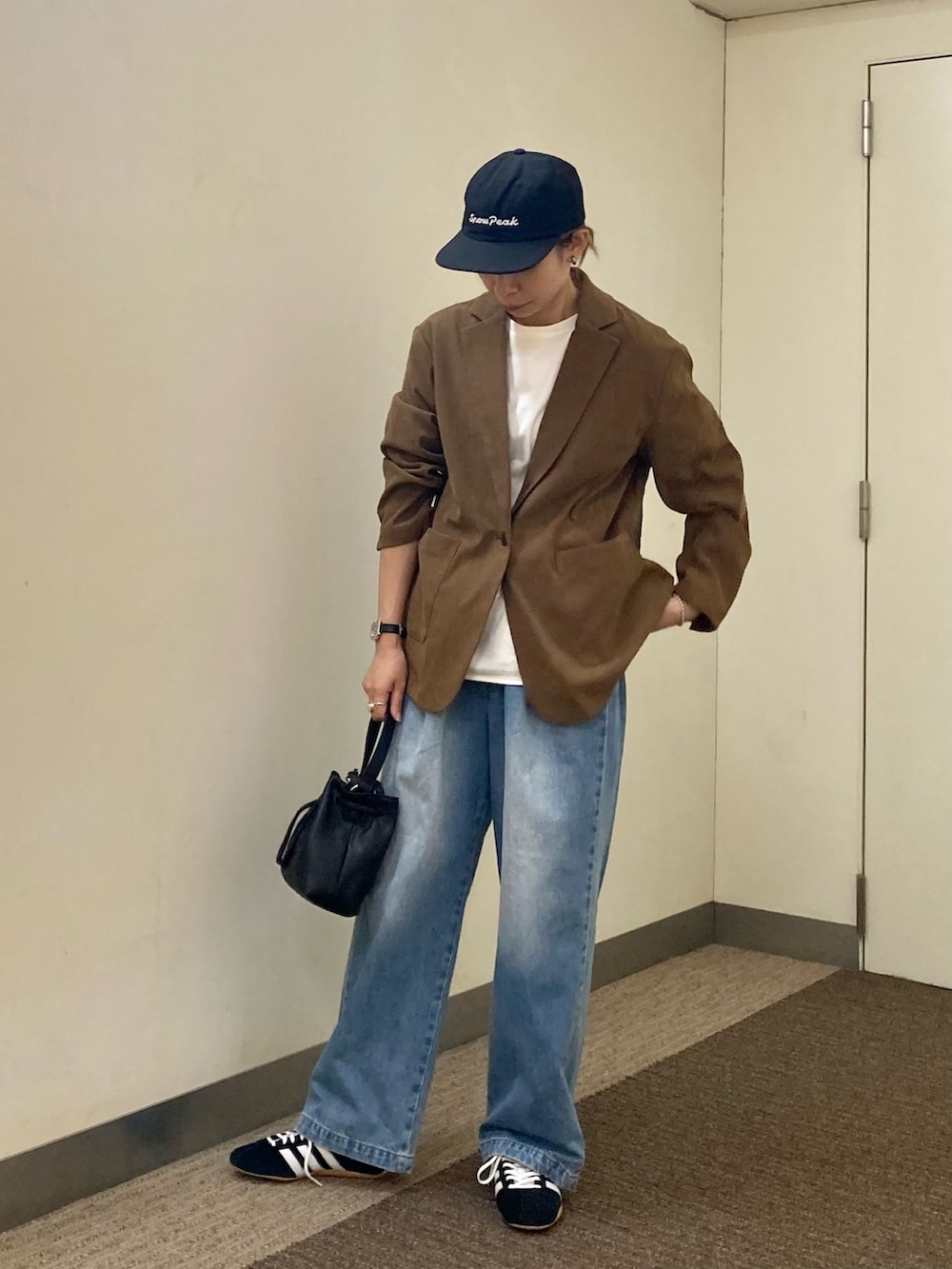 ホワイト系のTシャツ/カットソー、ベージュ系のその他アウター、ブルー系のデニムパンツを着用したレディースの秋コーディネートの2枚目の写真