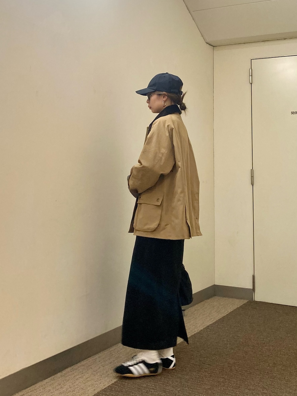 ベージュ系のその他アウター、ブラック系のスカート、ブラック系のショルダーバッグを着用したレディースの秋コーディネートの2枚目の写真