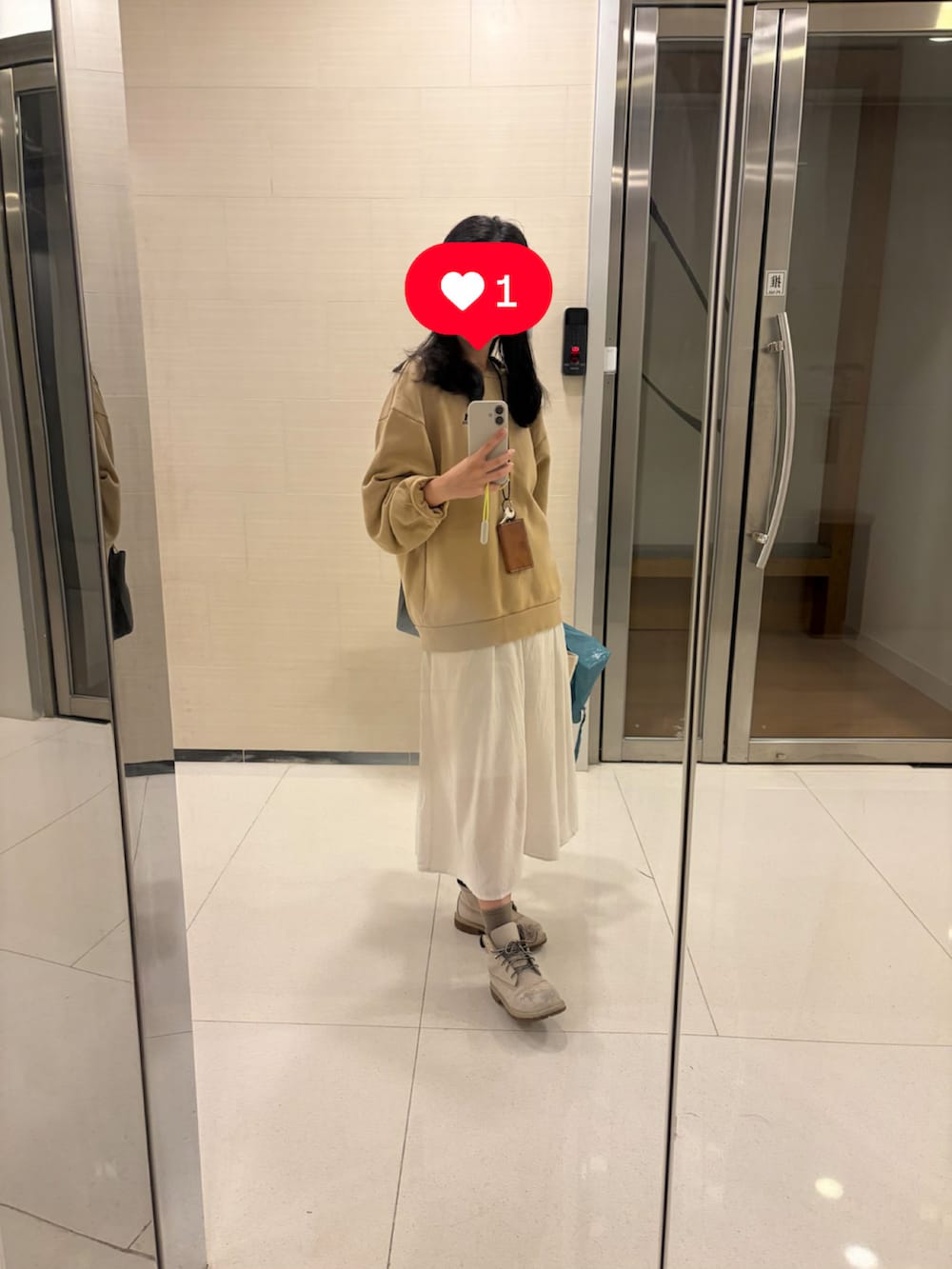 ベージュ系のスウェット、ベージュ系のワンピース/ドレス、グレー系のブーツを着用したレディースの秋コーディネートの2枚目の写真