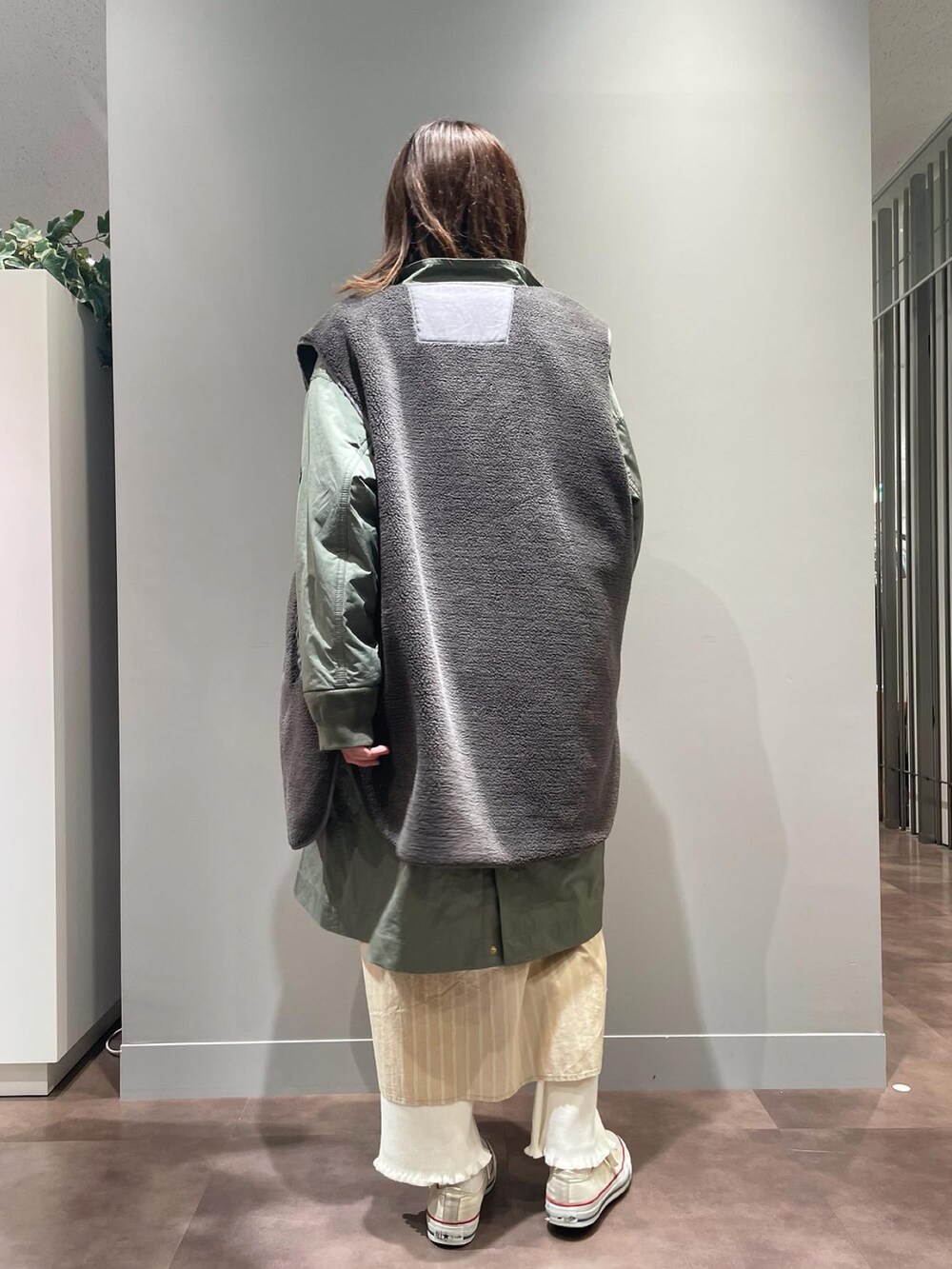 ホワイト系のスニーカー、ホワイト系のその他パンツ、グリーン系のモッズコートを着用したレディースの秋コーディネートの3枚目の写真