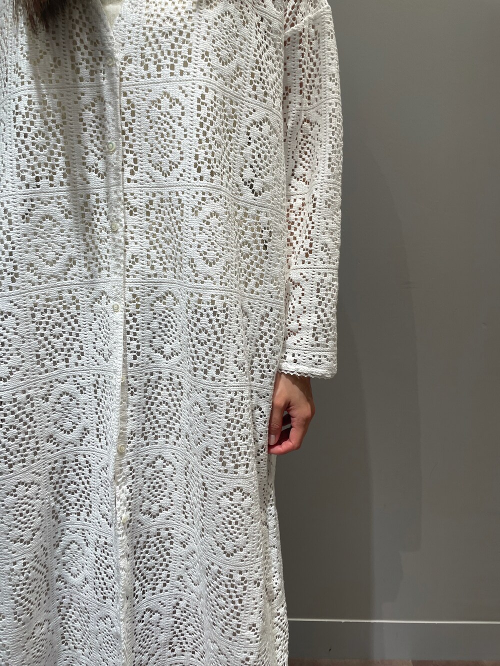 イエロー系のハンドバッグ、ホワイト系のワンピース、ベージュ系のスカートを着用したレディースの冬コーディネートの2枚目の写真