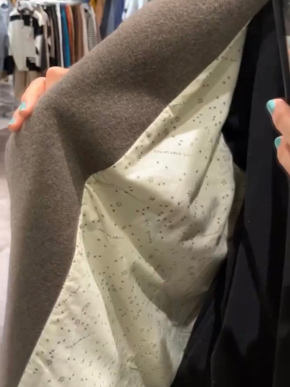 ブラウン系のノーカラーコート、ブラック系のワンピースを着用したレディースの冬コーディネートの2枚目の写真