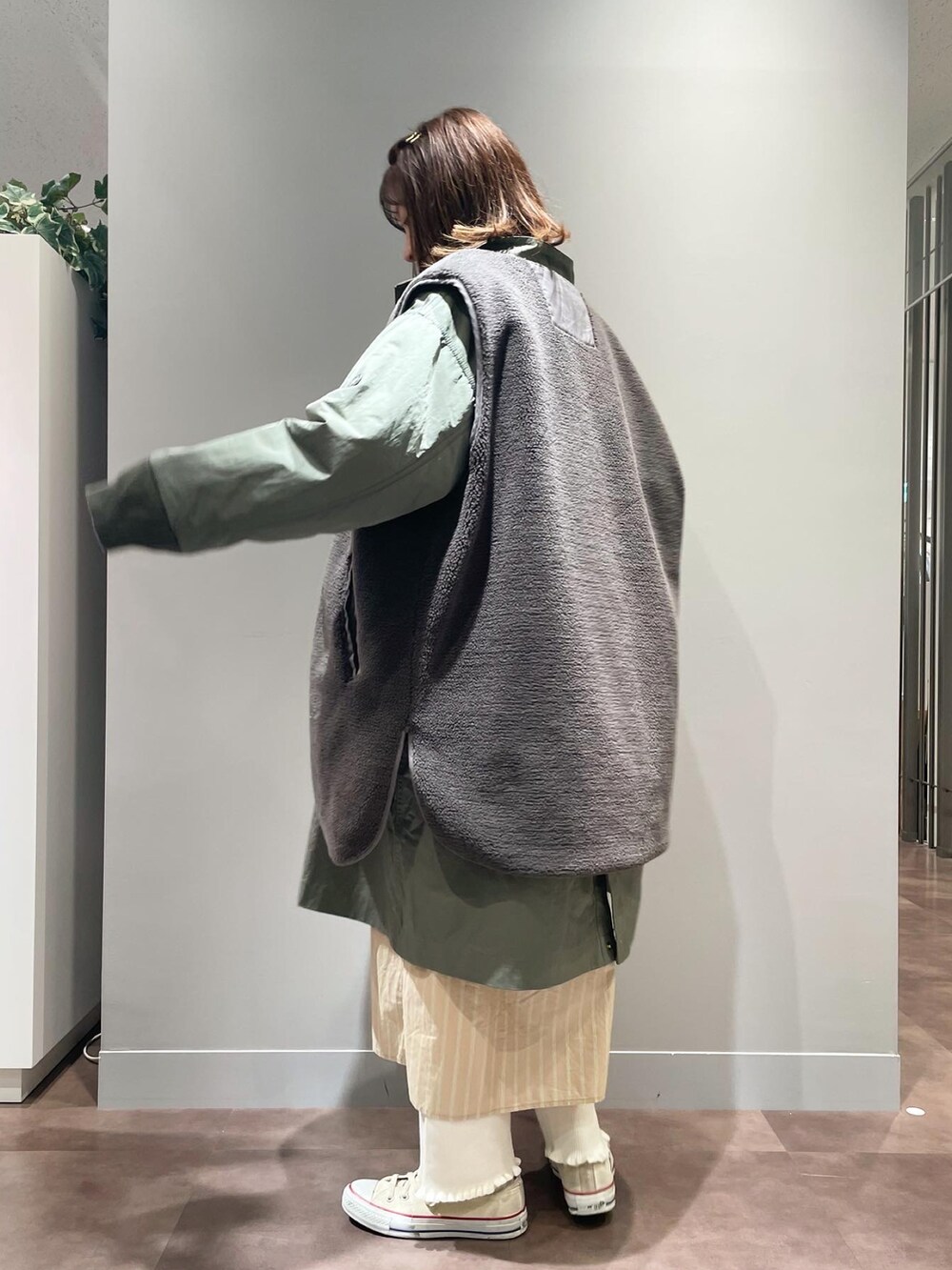 ホワイト系のスニーカー、ホワイト系のその他パンツ、グリーン系のモッズコートを着用したレディースの秋コーディネートの2枚目の写真