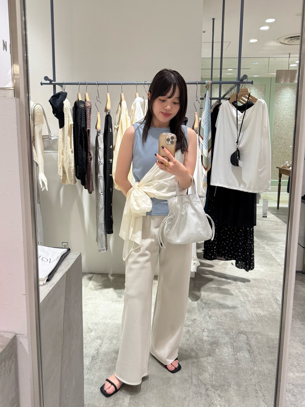ホワイト系のシャツ/ブラウス、シルバー系のトートバッグ、グレー系のその他パンツを着用したレディースの夏コーディネートの2枚目の写真