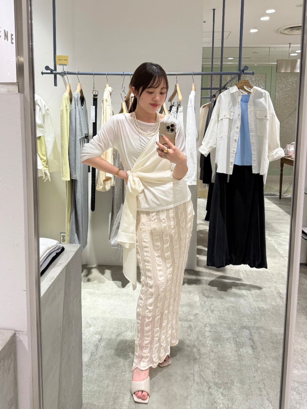 シルバー系のトートバッグ、ホワイト系のシャツ/ブラウス、ホワイト系のTシャツ/カットソーを着用したレディースの春コーディネートの2枚目の写真