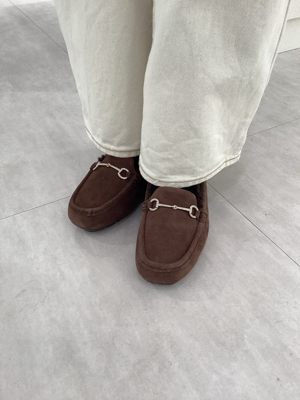 ブラック系のバッグ、ブラウン系のモカシン/デッキシューズを着用したレディースの冬コーディネートの2枚目の写真