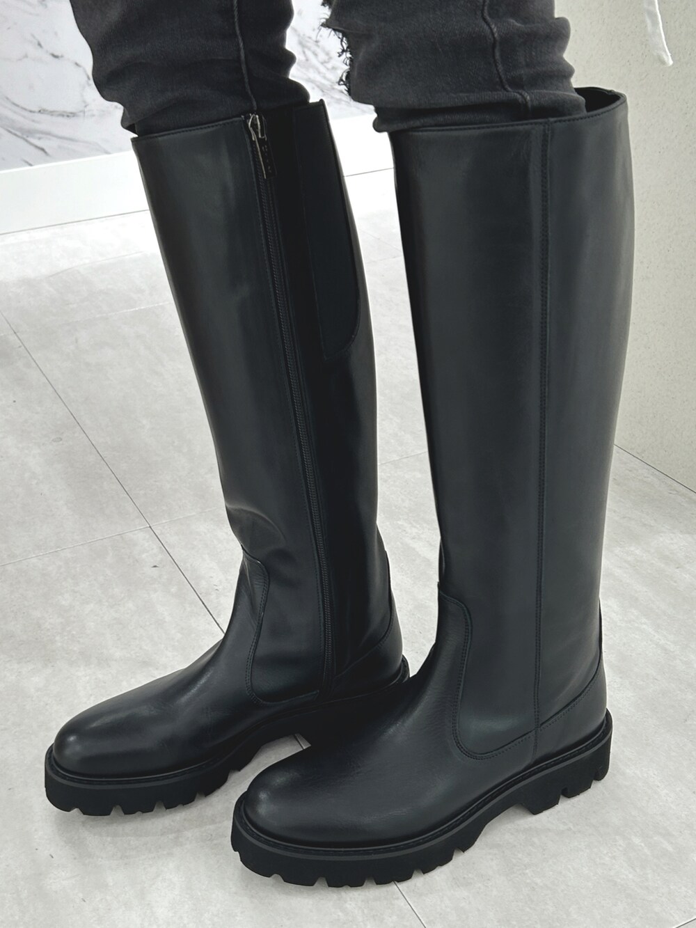 ブラック系のブーツを着用したレディースの秋コーディネートの2枚目の写真