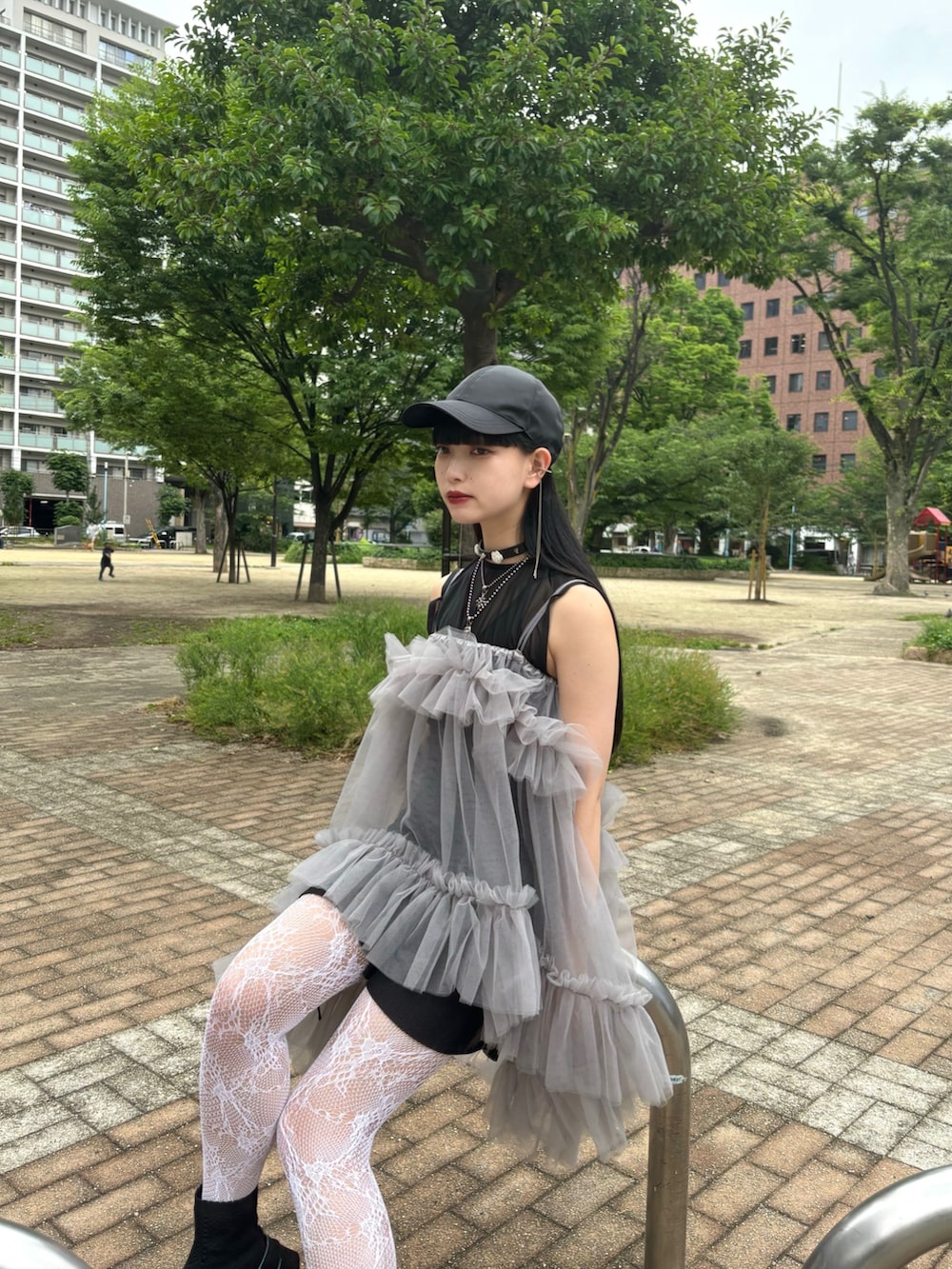グレー系のキャミソール、ブラック系のスニーカー、ブラック系のキャップを着用したレディースの夏コーディネートの3枚目の写真