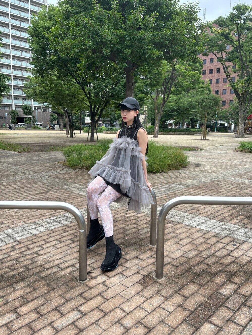 グレー系のキャミソール、ブラック系のスニーカー、ブラック系のキャップを着用したレディースの夏コーディネートの5枚目の写真