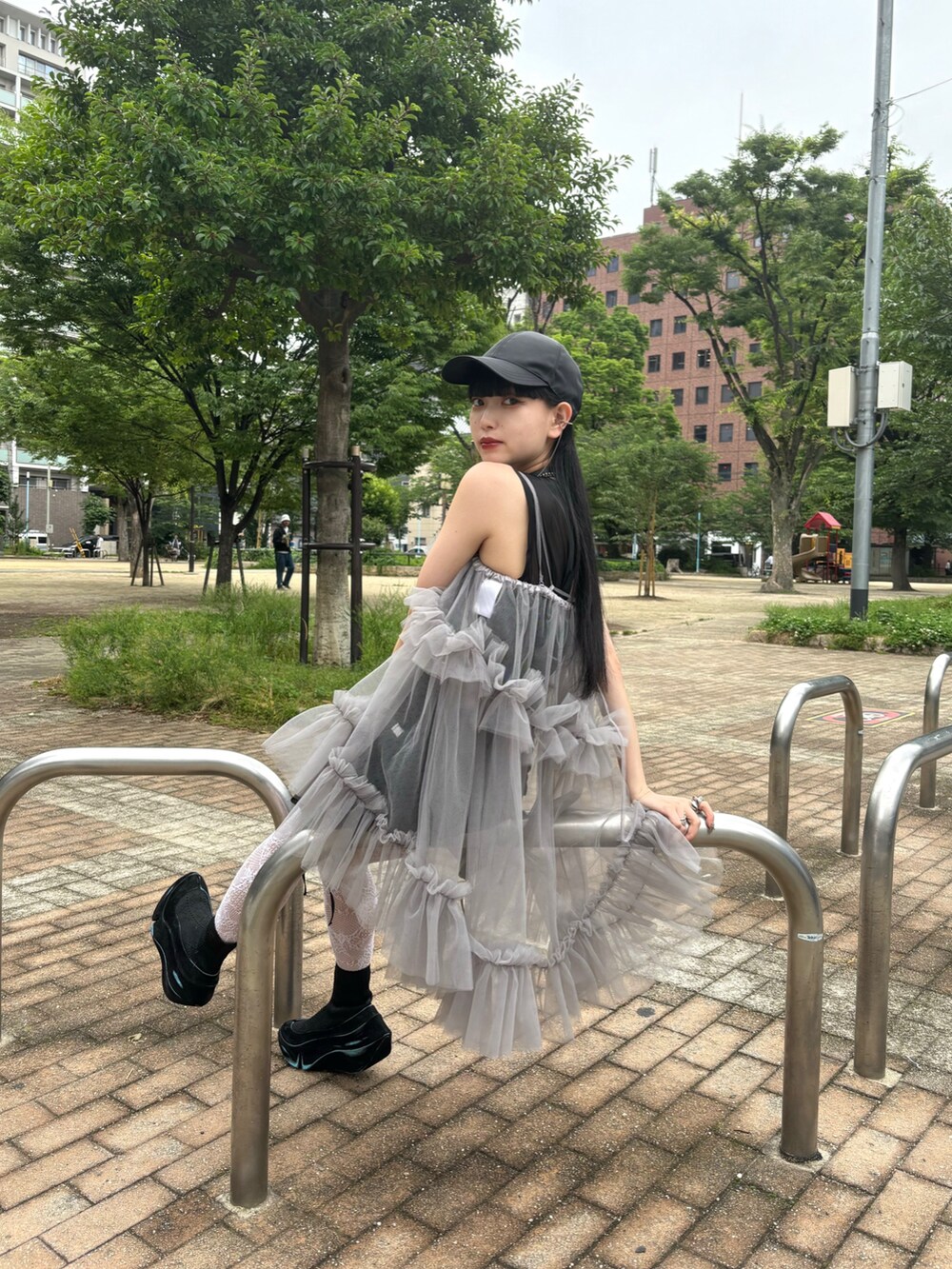 グレー系のキャミソール、ブラック系のスニーカー、ブラック系のキャップを着用したレディースの夏コーディネートの4枚目の写真