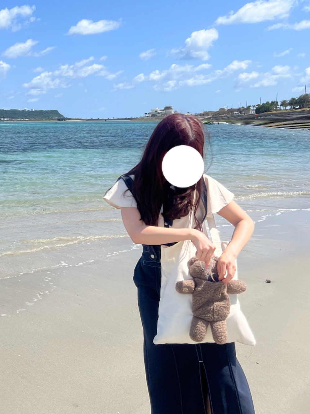 ブルー系のジャンパースカート、ブルー系のシャツ/ブラウス、ホワイト系のトートバッグを着用したレディースの春コーディネートの2枚目の写真