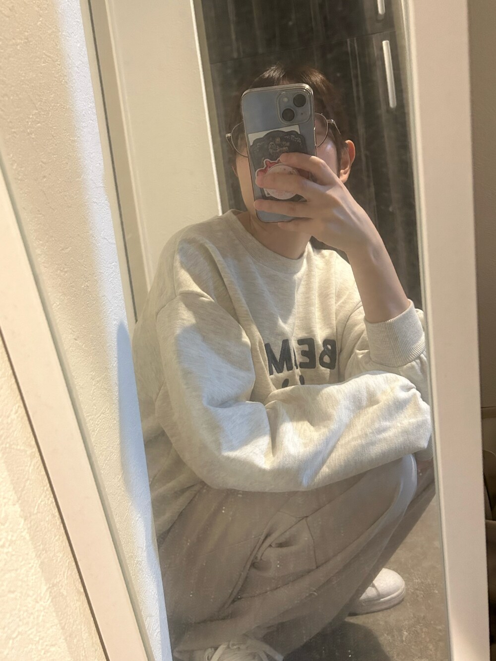 ホワイト系のパンツ、グレー系のスウェット、ブラック系のショルダーバッグを着用したレディースの秋コーディネートの2枚目の写真