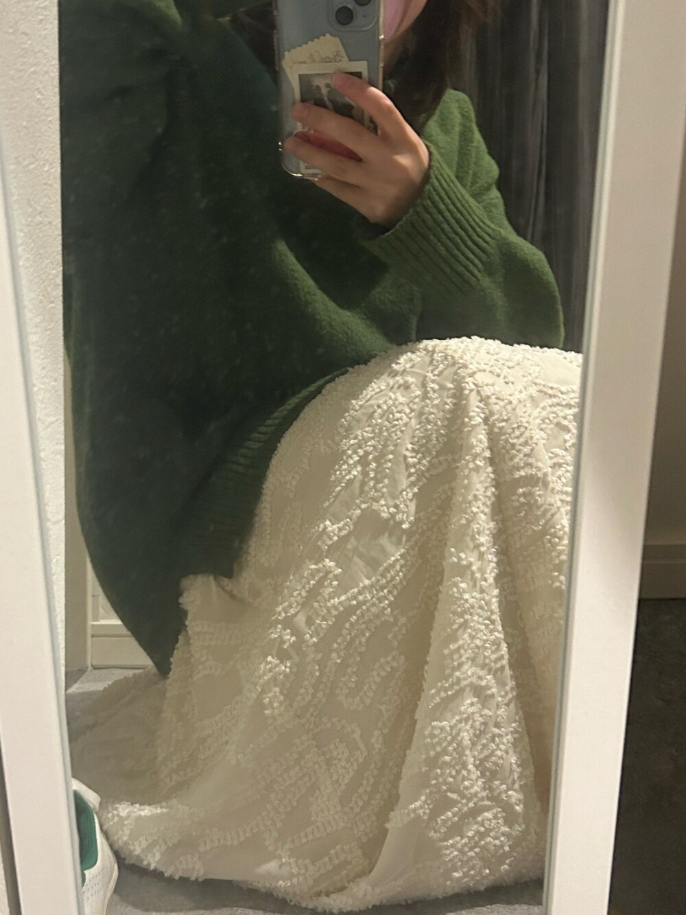 ブラウン系のブルゾン、グリーン系のニット/セーター、ホワイト系のスカートを着用したレディースの冬コーディネートの2枚目の写真