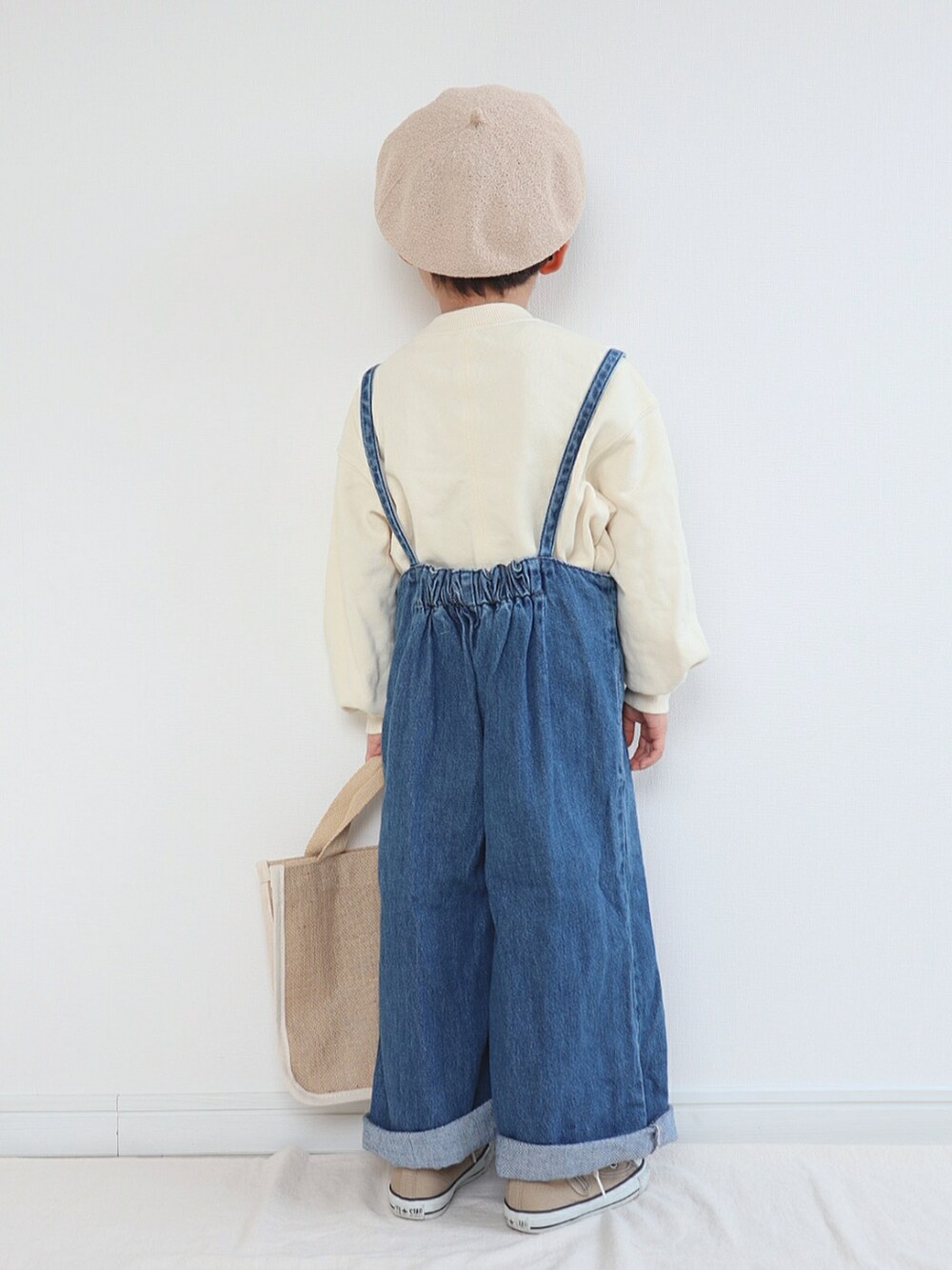 ホワイト系のスウェット、ブルー系のサロペット/オーバーオール、ベージュ系のトートバッグを着用したキッズの春コーディネートの3枚目の写真