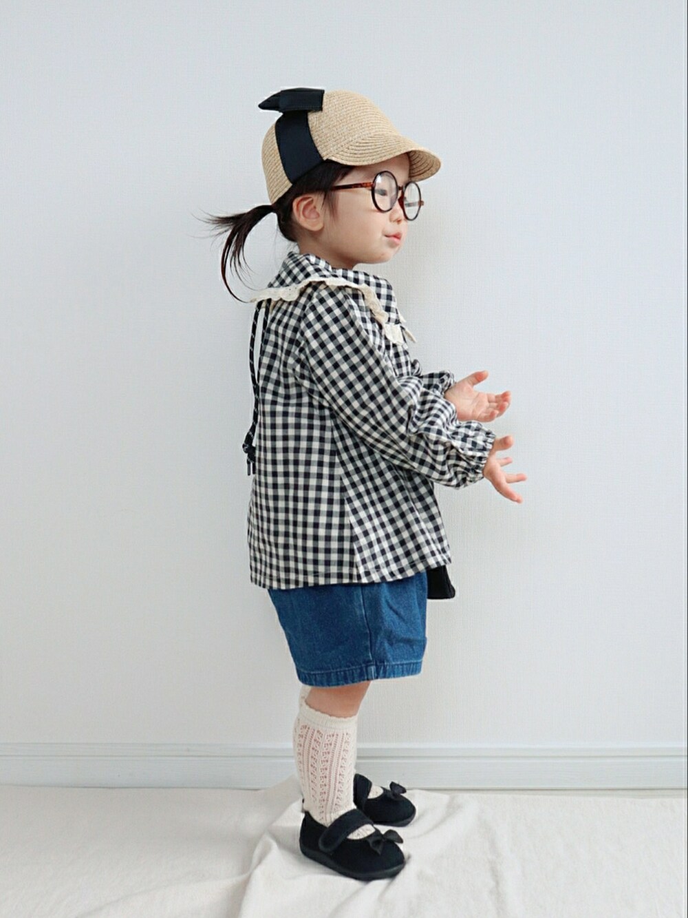 ブラック系のジャケット/アウター、ブラック系のショルダーバッグ、ブルー系のデニムパンツを着用したキッズの春コーディネートの2枚目の写真