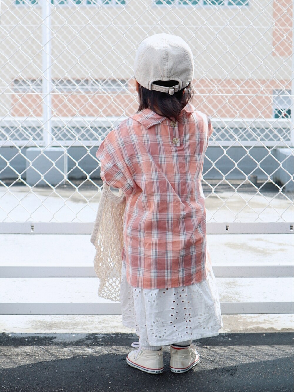 ピンク系のシャツ/ブラウス、ホワイト系のスカート、ホワイト系のスニーカーを着用したキッズの春コーディネートの3枚目の写真