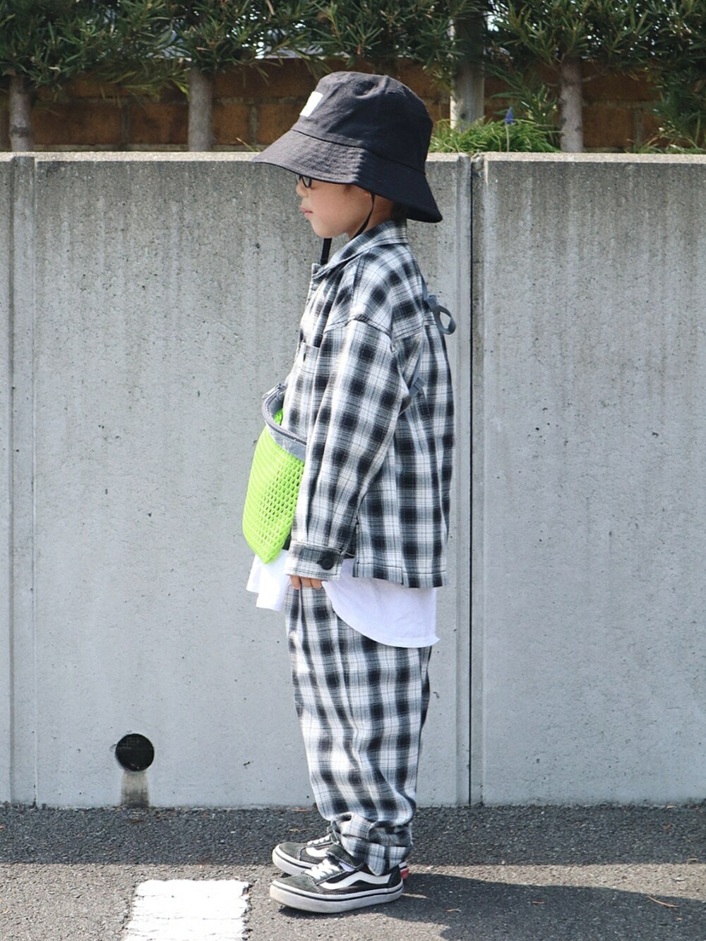 ブラック系のジャケット/アウター、ホワイト系のTシャツ/カットソー、グリーン系のショルダーバッグを着用したキッズの春コーディネートの2枚目の写真