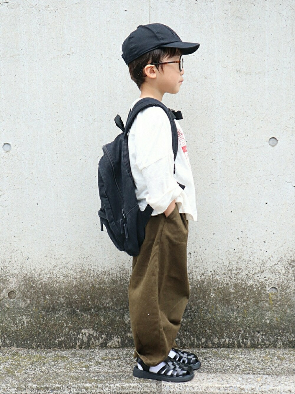 ホワイト系のTシャツ/カットソー、ブラック系のバックパック/リュック、グリーン系のその他パンツを着用したキッズの春コーディネートの2枚目の写真